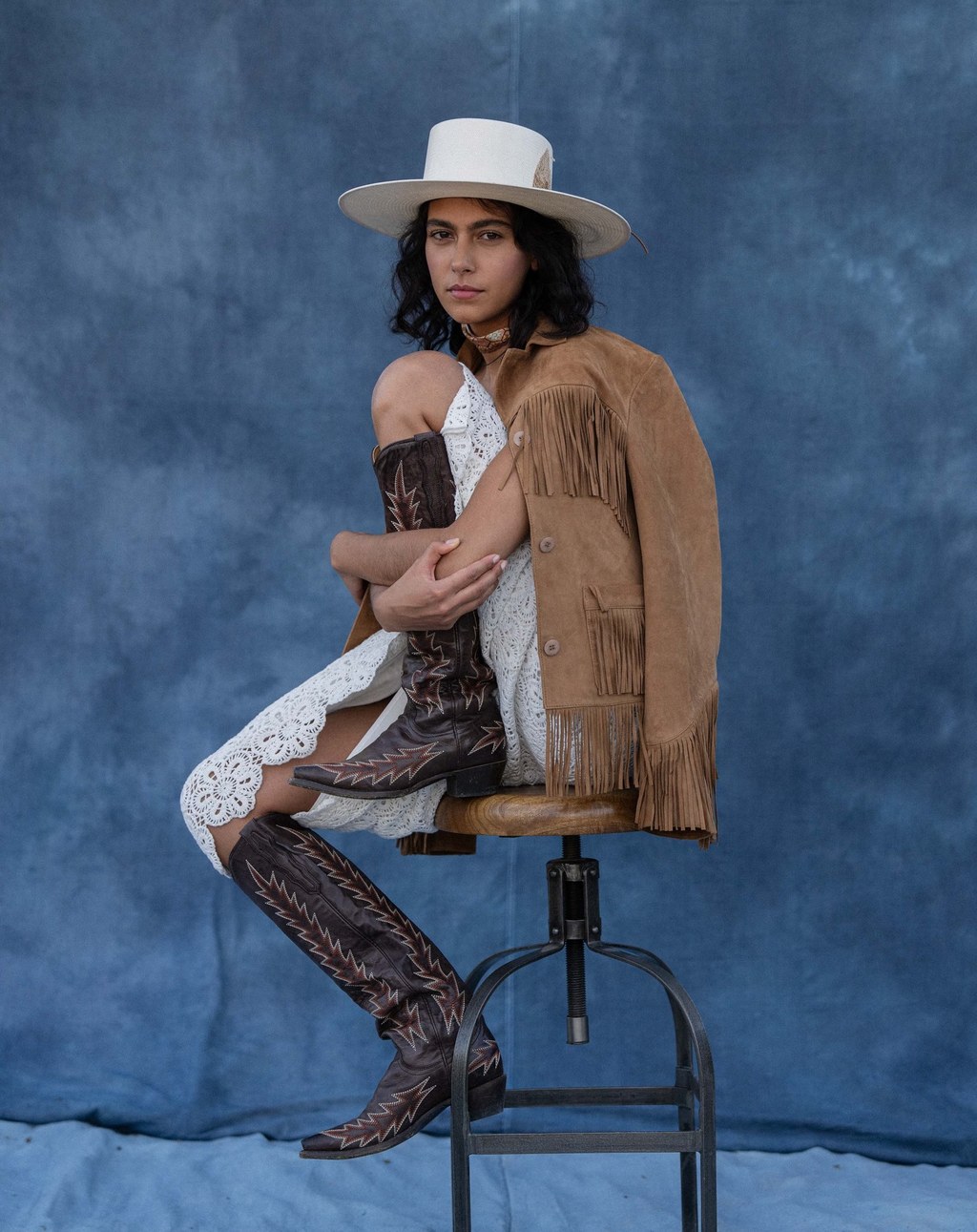 Stetson Western campaign: dark-haired woman seated in a white cowboy hat and fringe jacket