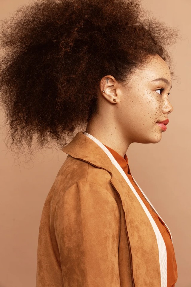 Commercial: freckled natural skin in profile with defined curls